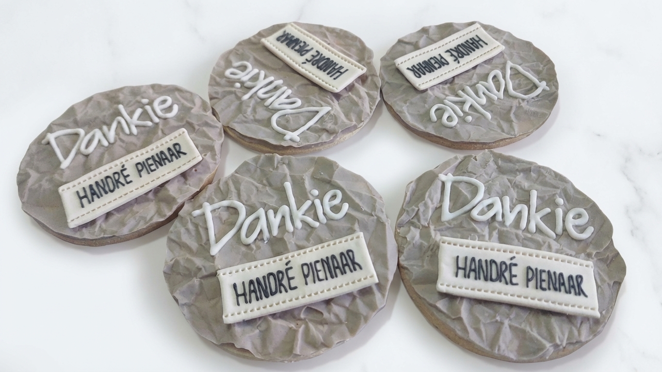 Personalised 'Dankie Handré Pienaar' royal icing cookies in grey and white with crinkled-paper texture effect